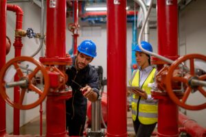 Two workers doing a fire alarm inspection in Miami